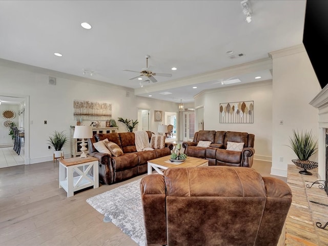 living room with light wood-type flooring, ceiling fan, and ornamental molding