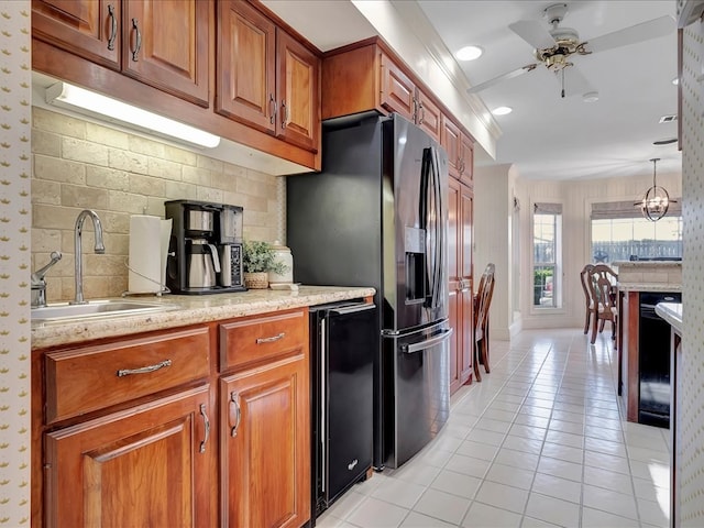 kitchen featuring ceiling fan with notable chandelier, black appliances, sink, pendant lighting, and light tile patterned floors