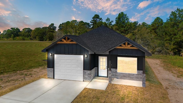 view of front of home with a garage and a lawn