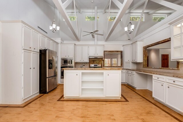 kitchen with stainless steel appliances, high vaulted ceiling, decorative light fixtures, ceiling fan with notable chandelier, and light wood-type flooring