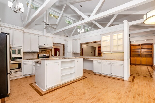 kitchen with white cabinetry, hanging light fixtures, stainless steel appliances, light hardwood / wood-style flooring, and a kitchen island