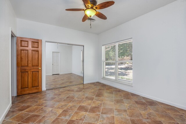 unfurnished bedroom with ceiling fan and a closet