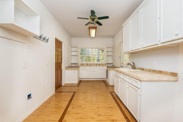 kitchen with white cabinets, light wood-type flooring, and sink