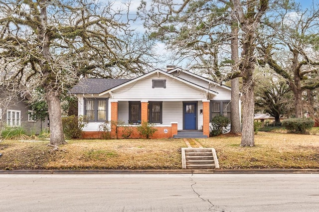 bungalow-style house with brick siding and a front lawn