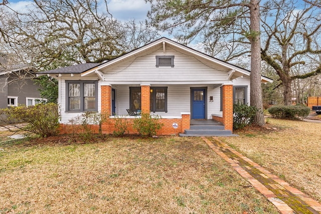 bungalow-style house featuring a porch, a front yard, and brick siding