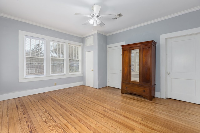 unfurnished bedroom with light wood-style floors, visible vents, crown molding, and baseboards