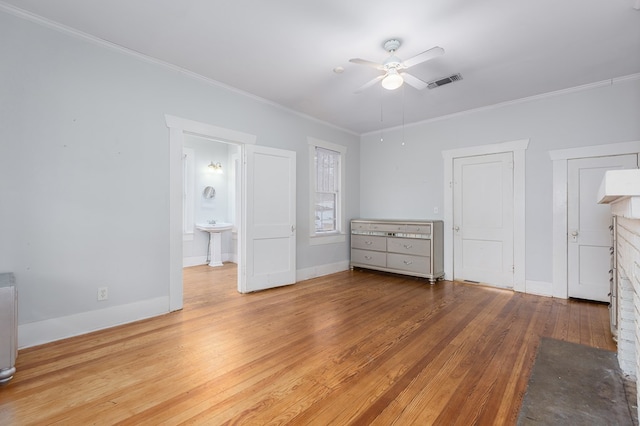 unfurnished bedroom featuring baseboards, wood finished floors, visible vents, and crown molding