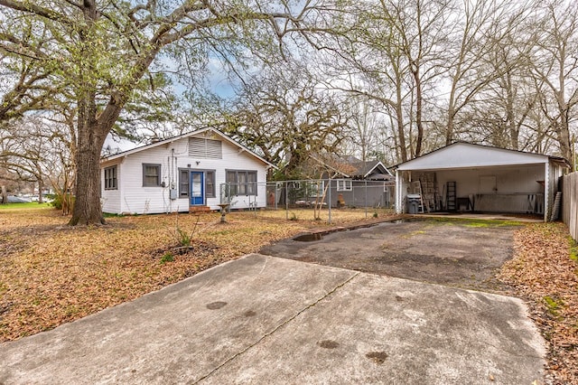 view of front of property featuring driveway and fence