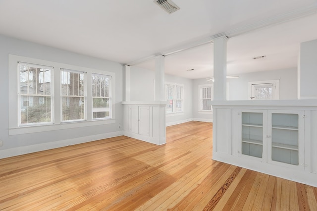 unfurnished living room with light wood finished floors, visible vents, and baseboards