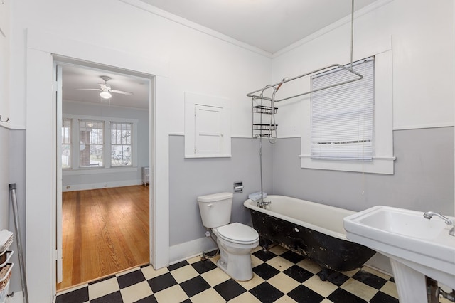 full bath with toilet, a soaking tub, ornamental molding, tile patterned floors, and a sink