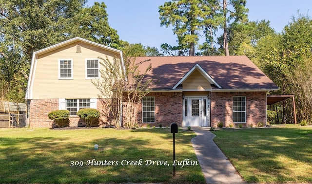view of front of house with a front yard, brick siding, and fence