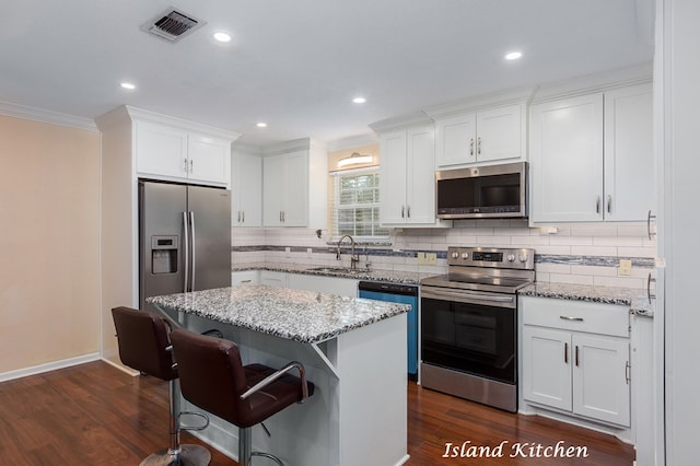 kitchen with a center island, white cabinetry, sink, and appliances with stainless steel finishes