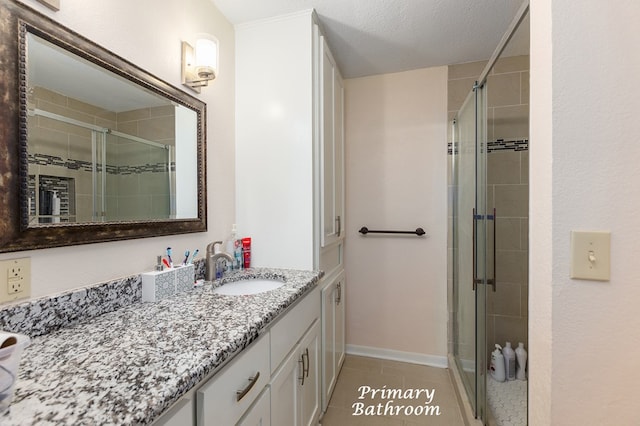 bathroom with tile patterned flooring, vanity, a textured ceiling, and a shower with door