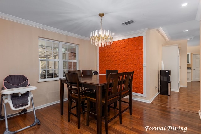 dining room featuring dark hardwood / wood-style flooring, ornamental molding, and an inviting chandelier