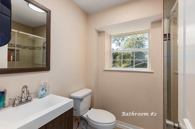 bathroom with an enclosed shower, vanity, and toilet