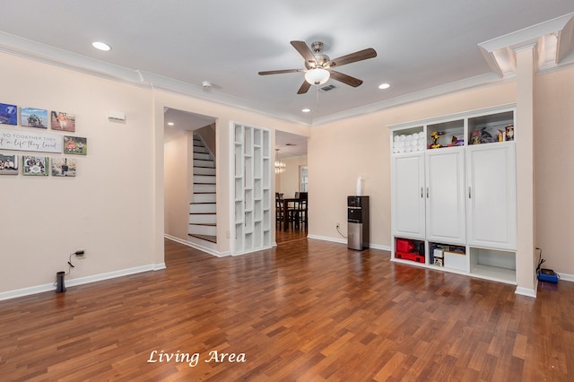 interior space featuring ceiling fan with notable chandelier, ornamental molding, and dark wood-type flooring