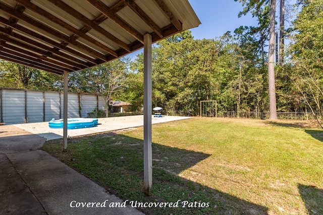 view of yard with a pool and a patio