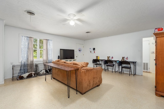 living room with ceiling fan and a textured ceiling