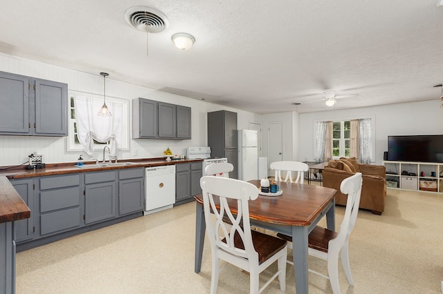 dining space with ceiling fan, sink, and a textured ceiling