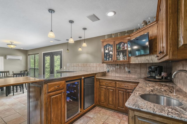 kitchen featuring kitchen peninsula, a wall unit AC, beverage cooler, and sink