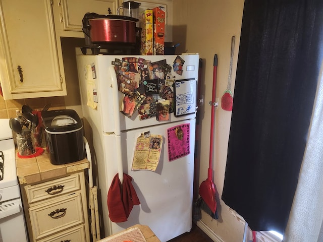 kitchen with freestanding refrigerator and tile counters