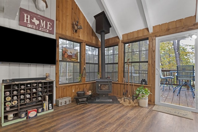 sunroom with vaulted ceiling with beams and a wood stove