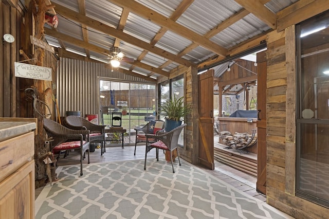 sunroom with ceiling fan and lofted ceiling with beams