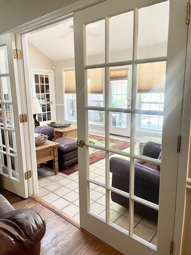 entryway with french doors, light wood-type flooring, and vaulted ceiling