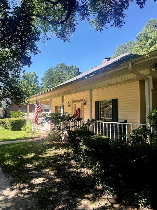 view of side of property featuring covered porch