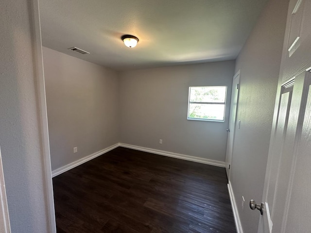 unfurnished room with dark wood-type flooring