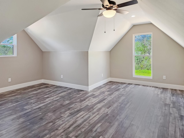 additional living space featuring hardwood / wood-style floors, vaulted ceiling, ceiling fan, and a healthy amount of sunlight