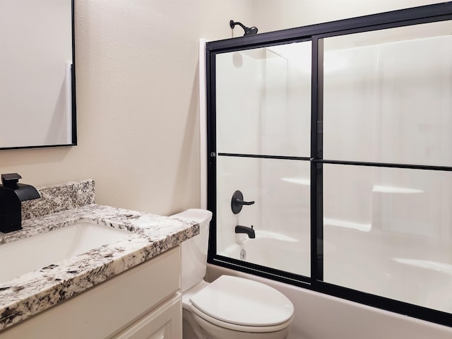 full bathroom featuring vanity, toilet, and shower / bath combination with glass door