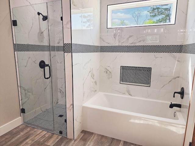 bathroom featuring plus walk in shower and hardwood / wood-style flooring