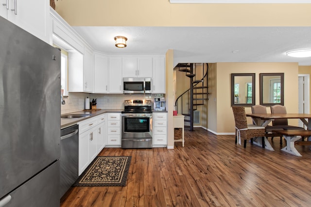 kitchen with white cabinets, stainless steel appliances, and dark hardwood / wood-style floors