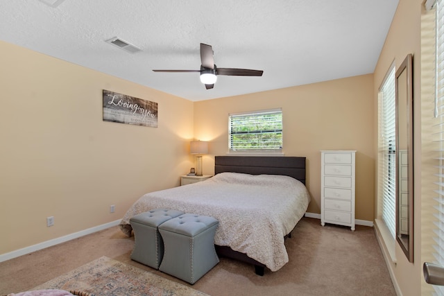 carpeted bedroom with ceiling fan and a textured ceiling