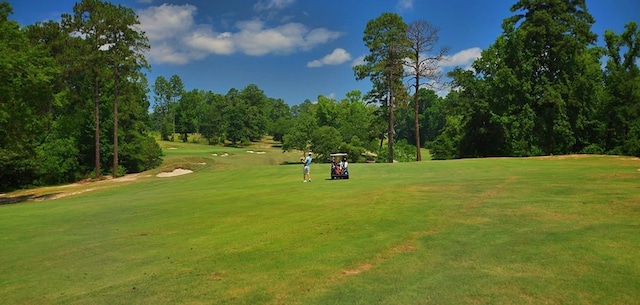 view of home's community featuring a lawn and view of golf course