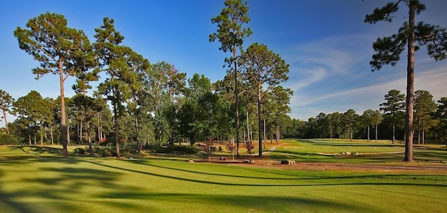 view of home's community with a lawn and view of golf course