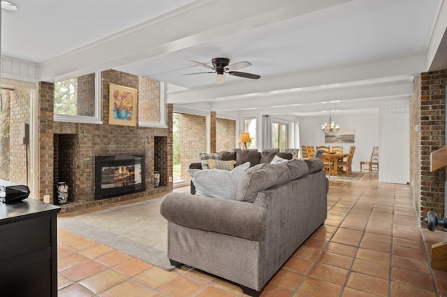 tiled living room with ceiling fan with notable chandelier, a fireplace, and brick wall