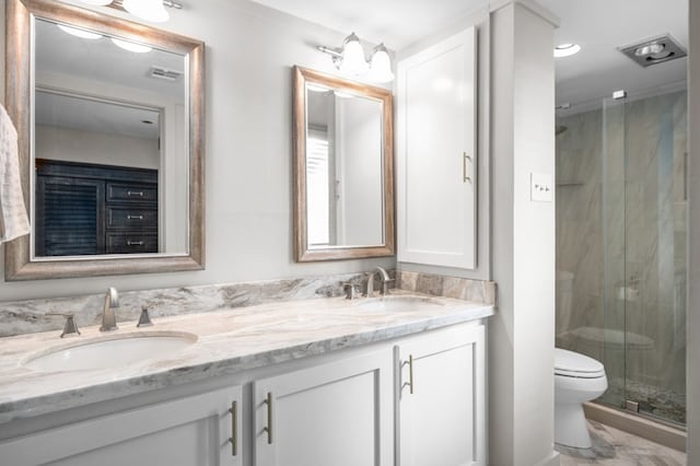 bathroom featuring vanity, toilet, and a shower with shower door