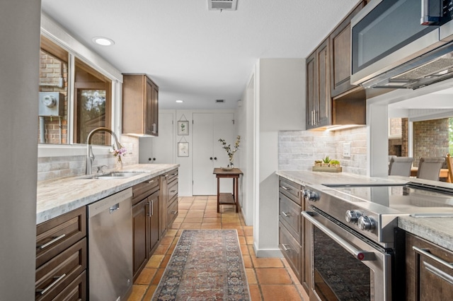 kitchen featuring appliances with stainless steel finishes, tasteful backsplash, a healthy amount of sunlight, and sink