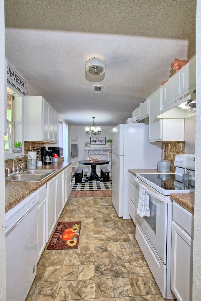 kitchen featuring tasteful backsplash, white appliances, sink, white cabinetry, and hanging light fixtures