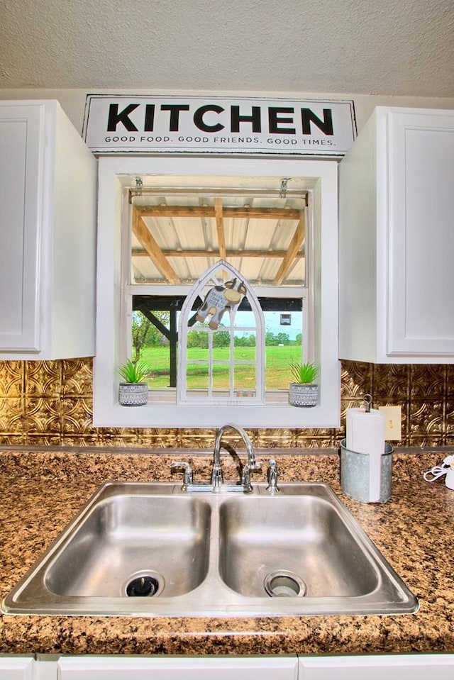 details with backsplash, sink, and white cabinets