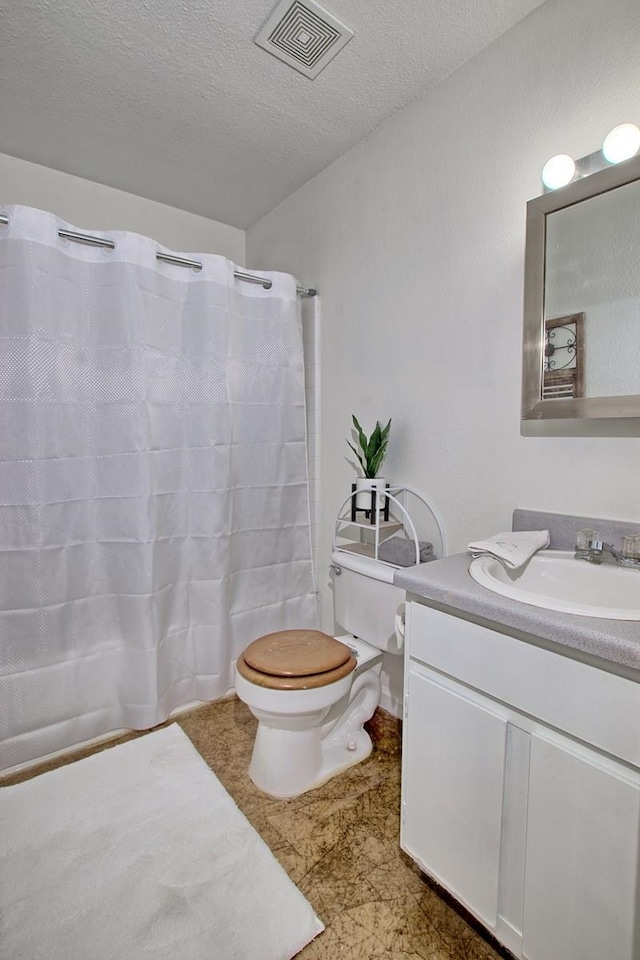 bathroom featuring vanity, a shower with shower curtain, a textured ceiling, and toilet