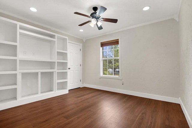 empty room featuring built in shelves, ceiling fan, ornamental molding, and dark hardwood / wood-style floors