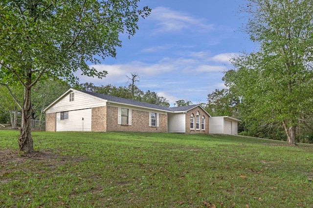 view of front of property featuring an outbuilding, a garage, and a front lawn