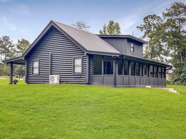 rear view of house with a lawn, a sunroom, and ac unit