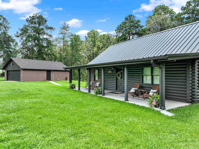 view of yard with a garage, a patio area, and an outdoor structure