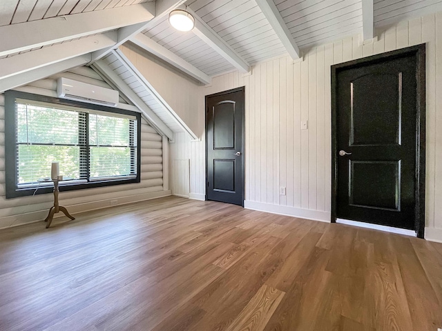 interior space with a wall mounted air conditioner, vaulted ceiling with beams, hardwood / wood-style flooring, and wooden ceiling