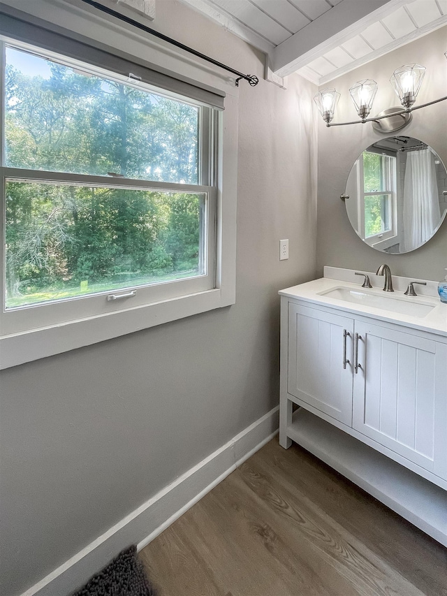 bathroom featuring hardwood / wood-style floors, vanity, a wealth of natural light, and beam ceiling