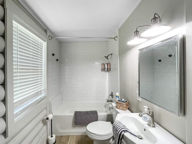 full bathroom featuring hardwood / wood-style flooring, toilet, tiled shower / bath, and sink